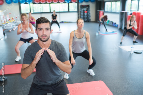 aerobics group members doing squat