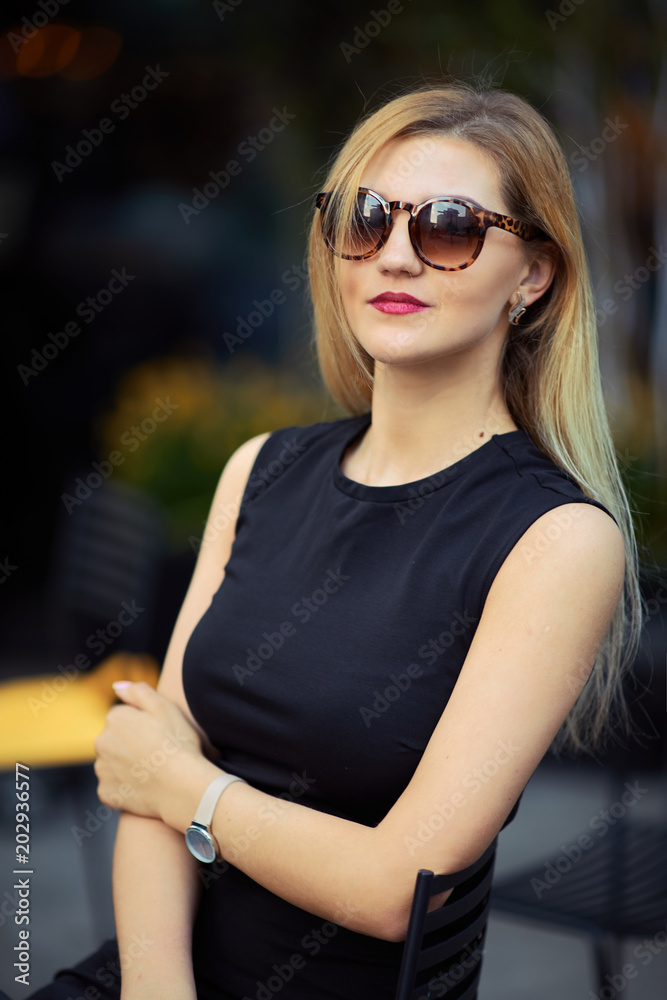 Beautiful girl sitting on the table and do her work, talk at phone, write mail Beautiful girl sitting on the table and do her work, talk at phone, write mail