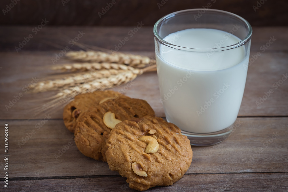 Glass of milk and peanut cookies on wooden background Glass of milk and peanut cookies on wooden background