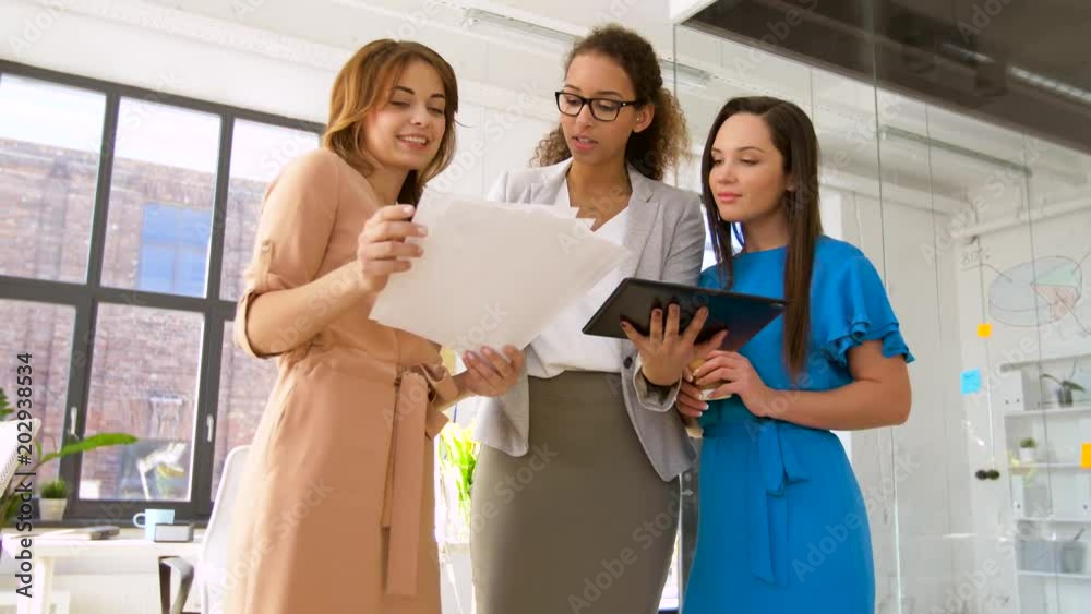 business, startup, planning and people concept - happy creative female team or businesswomen with papers, tablet pc computer and charts at office business, startup, planning and people concept - happy creative female team or businesswomen with papers, tablet pc computer and charts at office