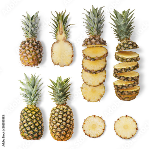 Juicy ripe pineapples of different varieties are whole and cut on a white background. From top view.