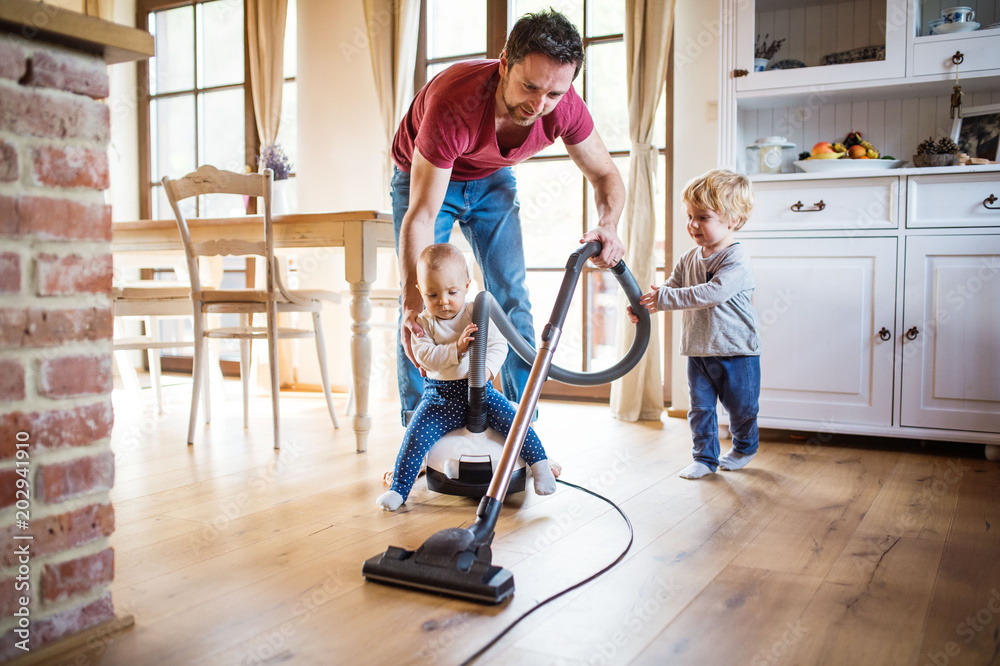 Father and two toddlers doing housework. - obrazy, fototapety, plakaty 