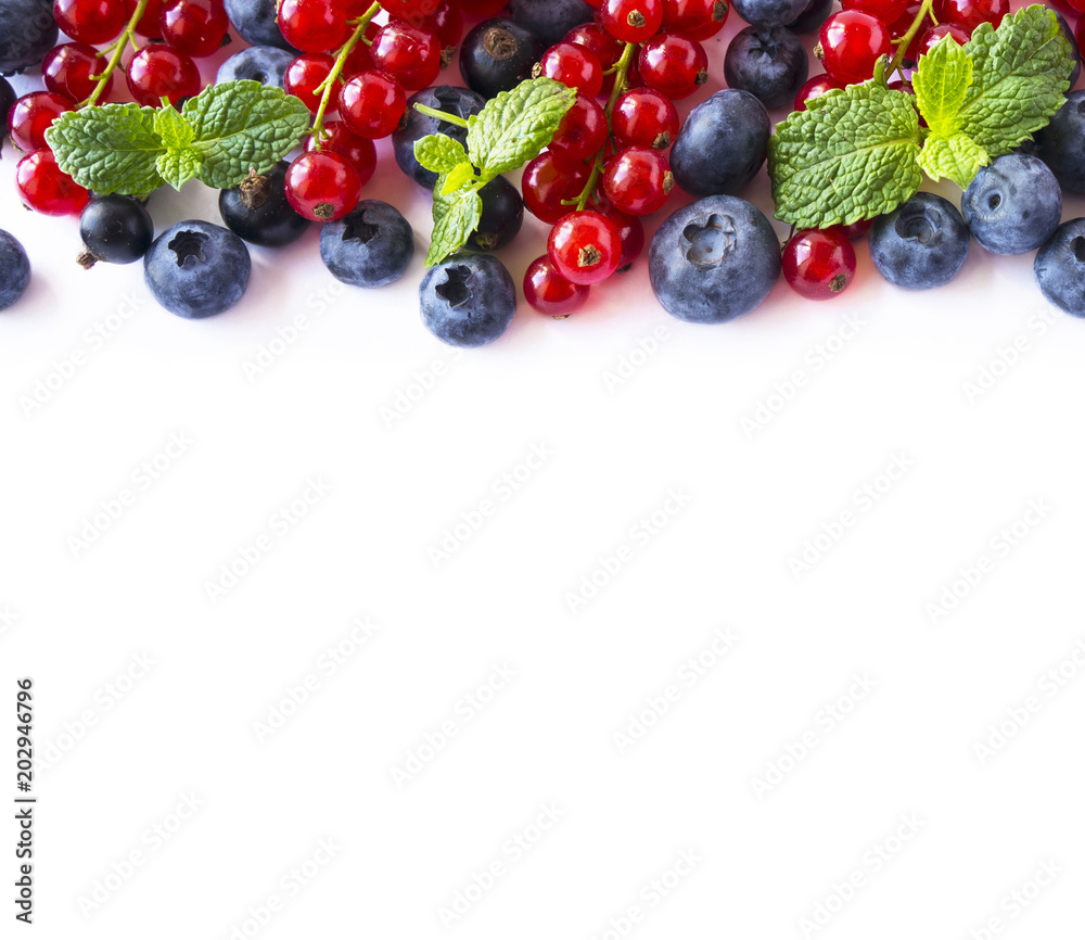 Mix berries and fruits at border of image with copy space for text. Ripe blueberries, red and black currants on white background. Top view. Black-blue and red food. Mix berries and fruits at border of image with copy space for text. Ripe blueberries, red and black currants on white background. Top view. Black-blue and red food.