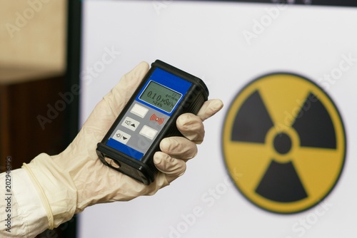 Radiation supervisor in glove with geiger counter checks the level of radiation photo