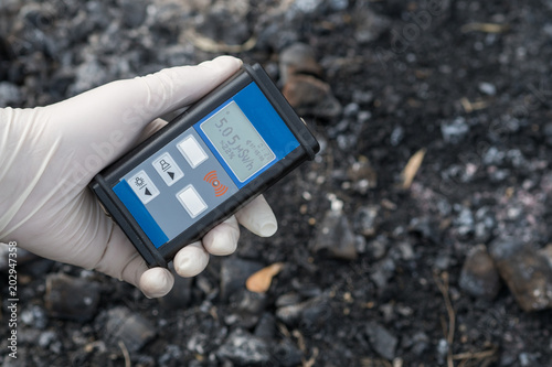 Radiation supervisor in glove with geiger counter checks the level of radiation photo