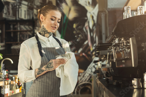Fotografie Portrait of tattooed barista at coffee shop counter