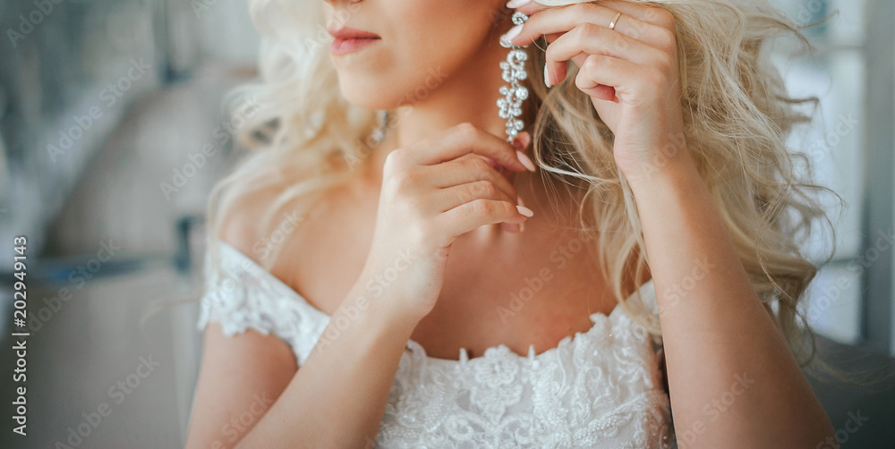 The bride corrects the earring, Beautiful earrings and hands of the bride