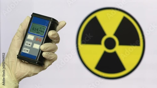 Radiation supervisor in glove with geiger counter checks the level of radiation photo