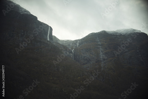 Paisaje montañoso con cascadas un día nublado y gris 