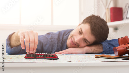 Man dreaming about travel, looking at map photo