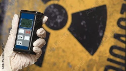 Radiation supervisor in glove with geiger counter checks the level of radiation photo