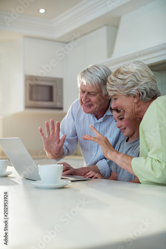 Grandson using laptop with grandparents