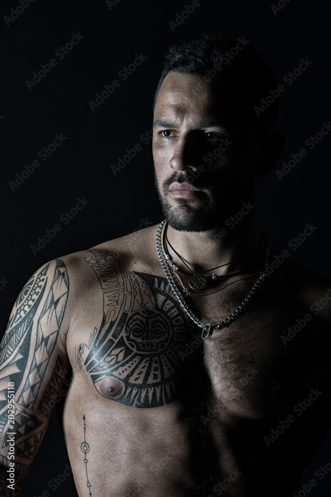 Macho with sexy bare torso. Bearded man with tattooed chest. Fit model with tattoo  art on