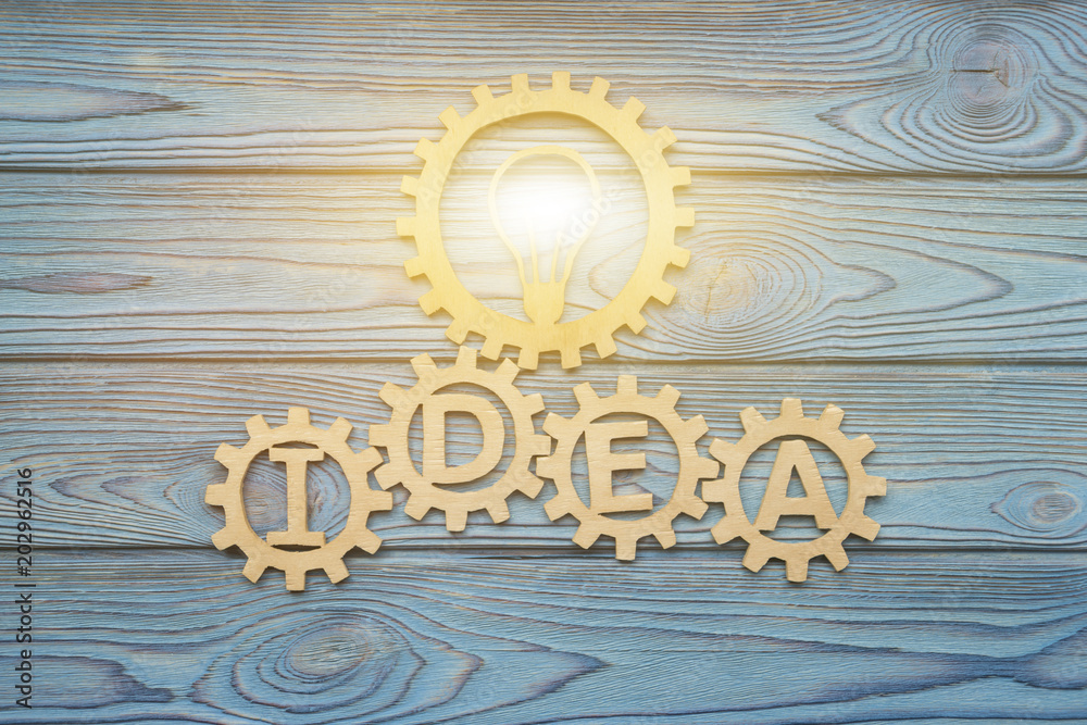 IDEA burning lamp in gears composed of puzzle pieces, on a blue background  of wood texture. Business concept, teamwork, cooperation, strategy,  innovation, creativity Stock Photo | Adobe Stock
