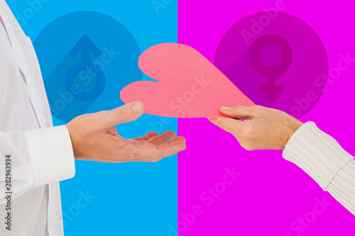 Woman handing man a paper heart against pink and blue