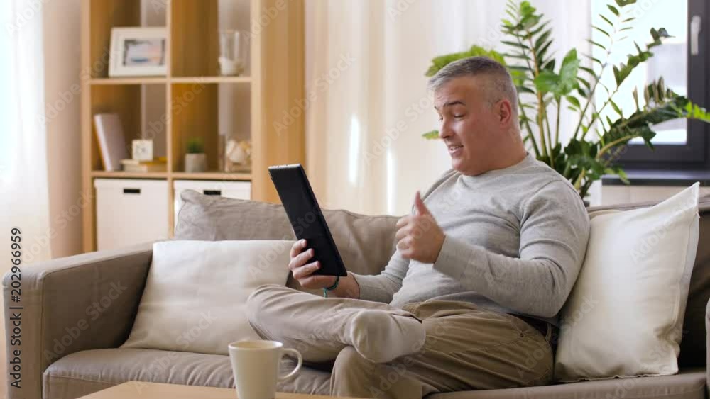 technology, people and communication concept - happy man with tablet pc computer having video chat at home technology, people and communication concept - happy man with tablet pc computer having video chat at home