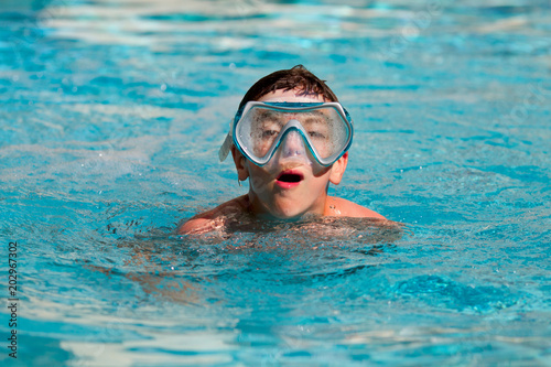 Teenager boy wearing mask swimming in the pool  © mirkadirka
