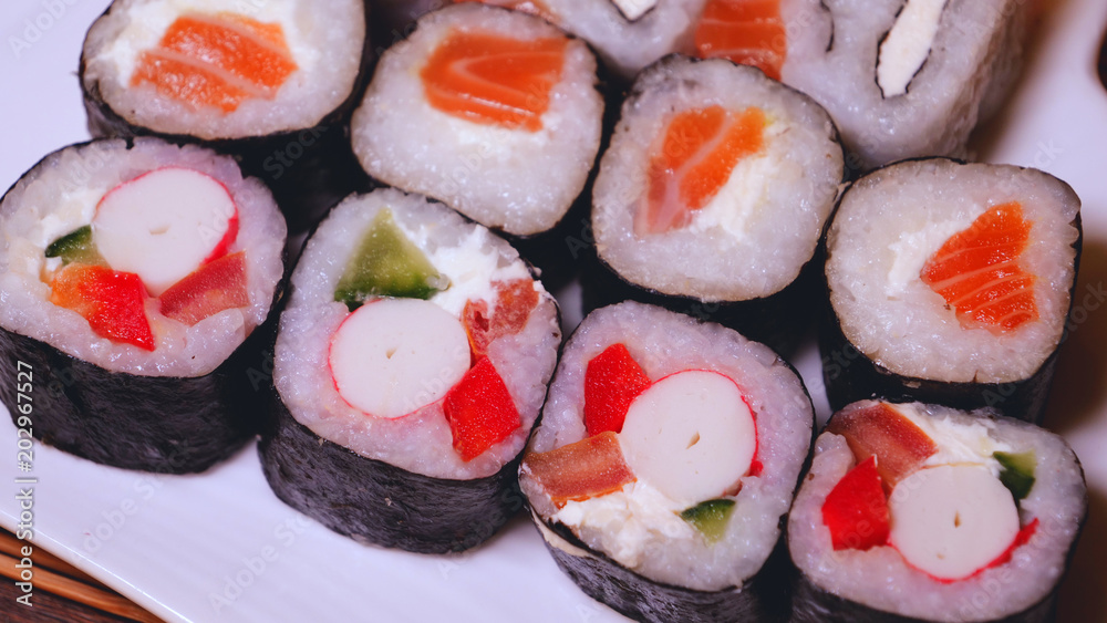 Fresh sushi, Philadelphia cheese, crab sticks, salmon, rice, ginger, soy, orange background, macro. Fresh sushi, Philadelphia cheese, crab sticks, salmon, rice, ginger, soy, orange background, macro.