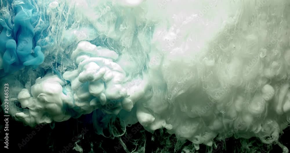 Blue and white ink spraying in water on black background shooting with 4k high speed camera.
