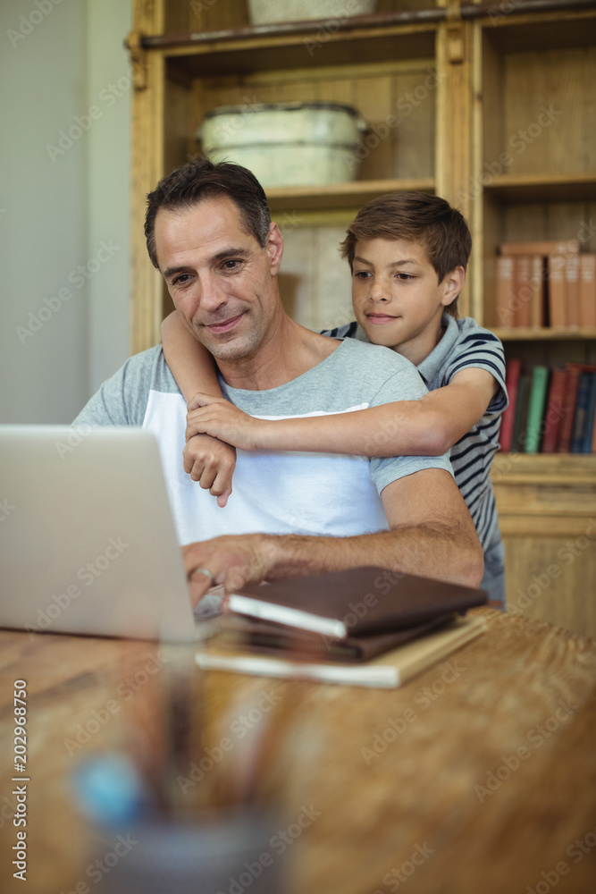 Father and son using laptop in study room Father and son using laptop in study room