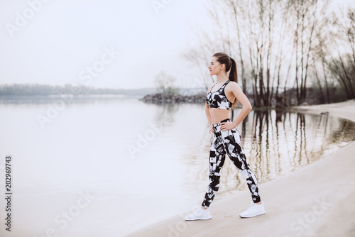 Young pretty fitness woman exercises during morning training workout photo