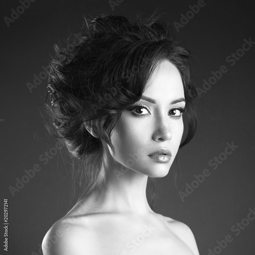 Beautiful woman with elegant hairstyle on black background