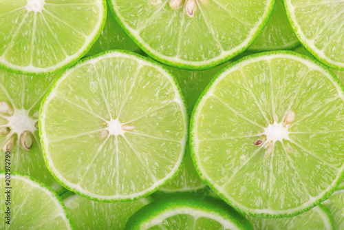 Green background with citrus fruit of lime slices.