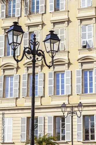 NICE, FRANCE, on March 9, 2018. The sun lights the beautiful ancient lamp decorating the street in a historical part of the city photo