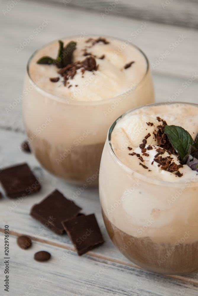 Iced Mocha Coffee with Whip Cream, Summer Drinking times. Coffee Beans. rustic textured Wooden Background. Mint Leaves Iced Mocha Coffee with Whip Cream, Summer Drinking times. Coffee Beans. rustic textured Wooden Background. Mint Leaves