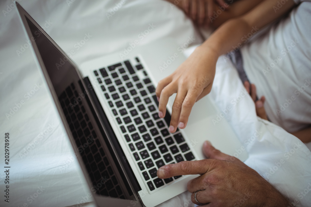 Parents and kids using laptop in bed Parents and kids using laptop in bed