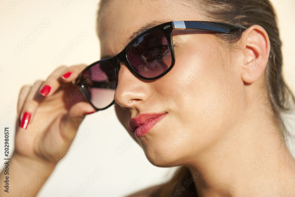 Girl face portrait, with sunglasses, red nail enamel, ponytail, red lipstick Girl face portrait, with sunglasses, red nail enamel, ponytail, red lipstick