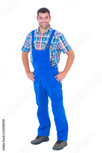 Handyman in coveralls standing hands on hip over white background