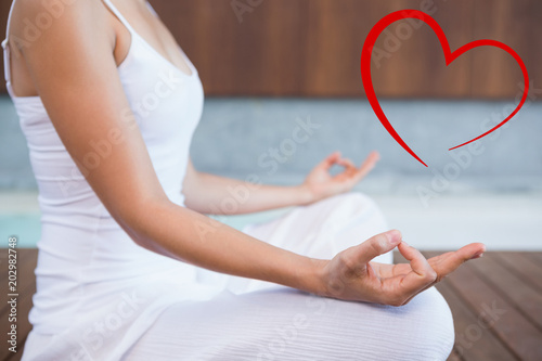 Peaceful woman in white sitting in lotus pose  against heart