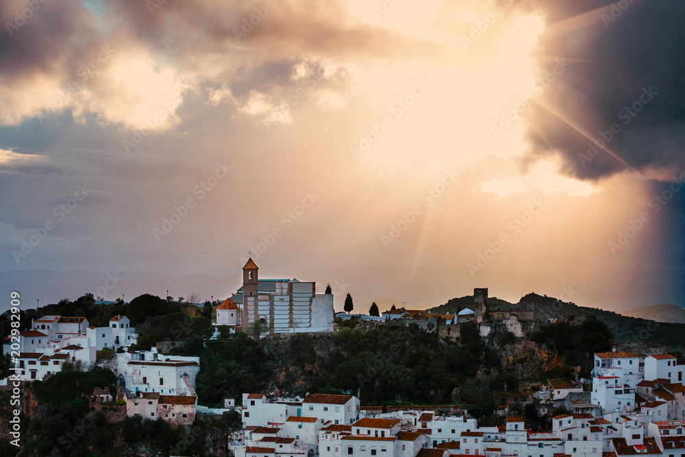 White Andalusian village - pueblo blanco - in the mountain range in Casares during sunset
