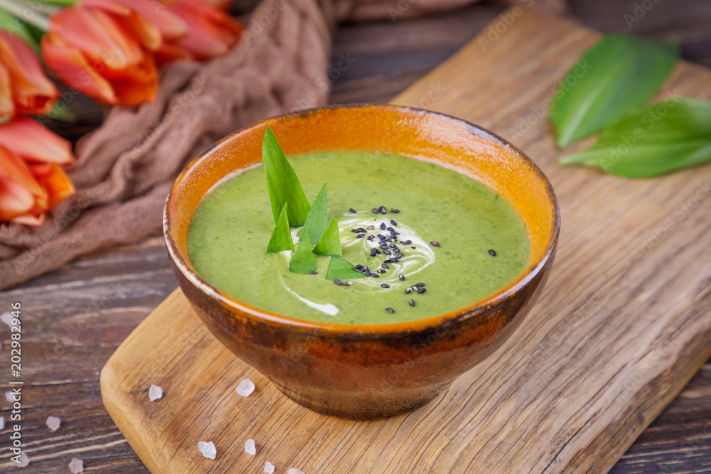 Homemade cream soup with wild leek on a wooden background. Rustic style Homemade cream soup with wild leek on a wooden background. Rustic style