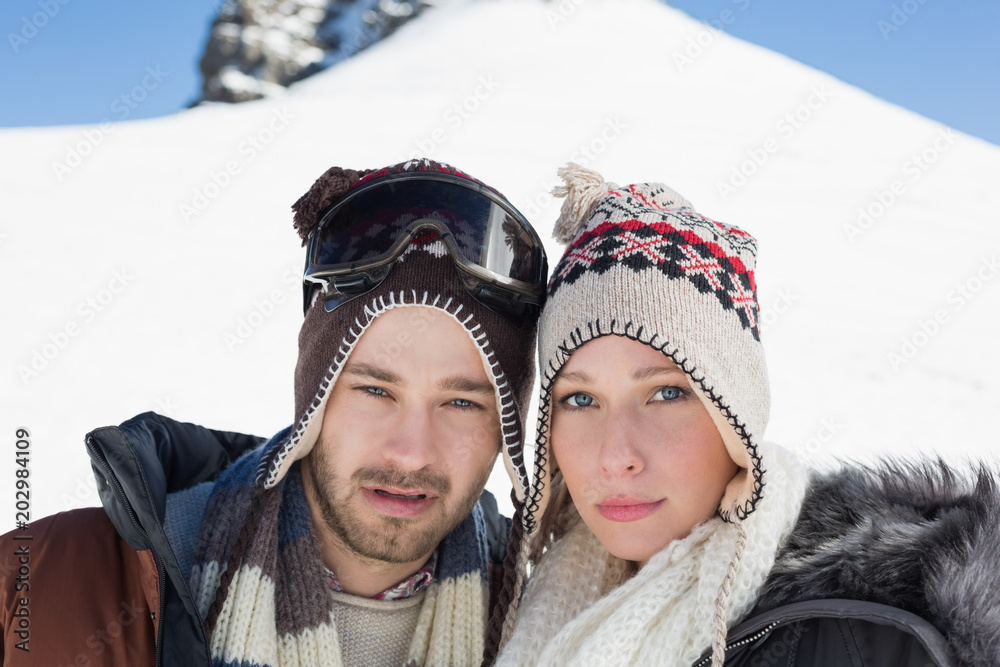 Couple in woolen hats on snow covered landscape