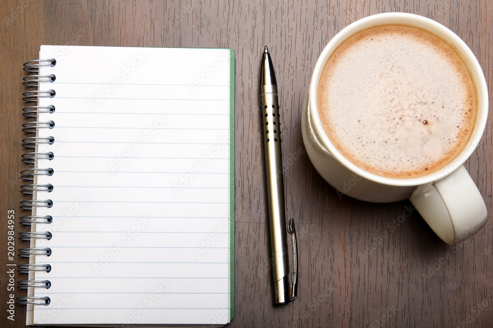 Blank notebook, pen and cup of coffee on wooden brown background, copy space. Blank notebook, pen and cup of coffee on wooden brown background, copy space.