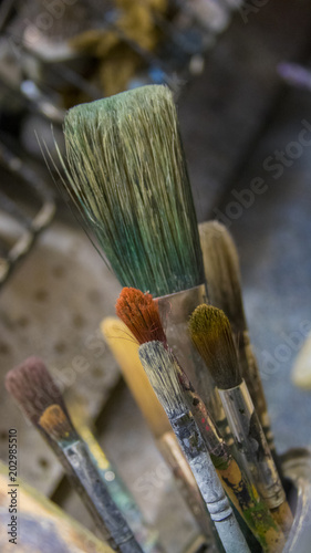 A jar full of paintbrushes and bristles 