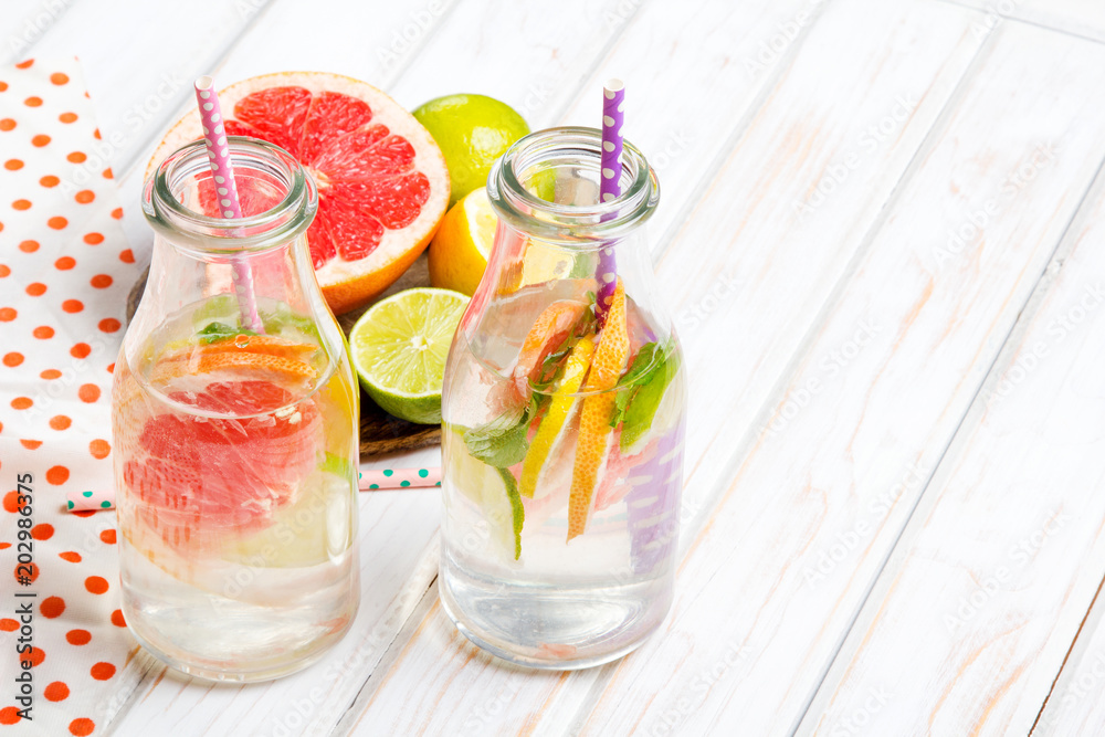 Infused flavored water with fresh fruits on white wooden background.Refreshing summer homemade detox water Infused flavored water with fresh fruits on white wooden background.Refreshing summer homemade detox water