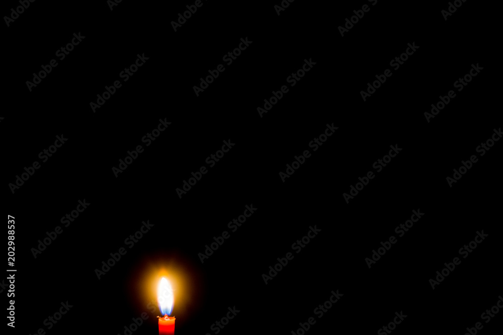 Fototapeta premium burning candle on black background