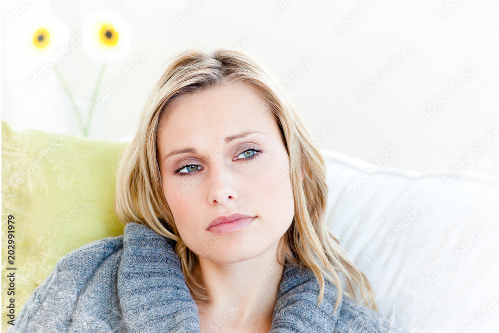 Exhausted woman lying on the sofa with a grey pullover against frost Exhausted woman lying on the sofa with a grey pullover against frost