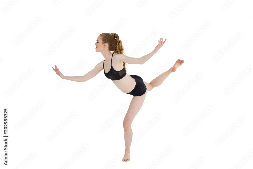 Side view of a sporty young woman standing on one leg Side view of a sporty young woman standing on one leg