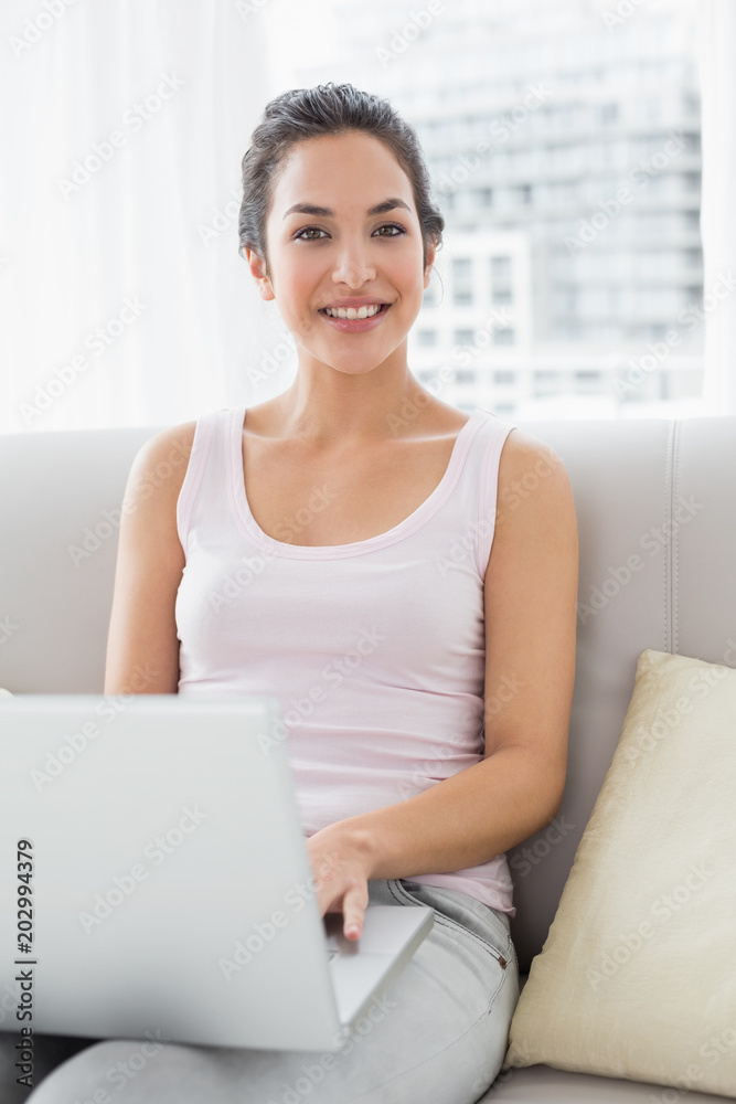 Portrait of a relaxed young woman using laptop on sofa Portrait of a relaxed young woman using laptop on sofa