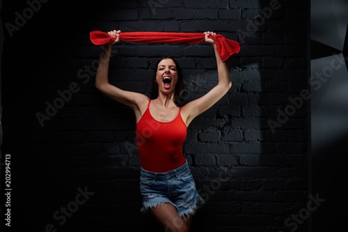 Young woman in red against black wall © nyul