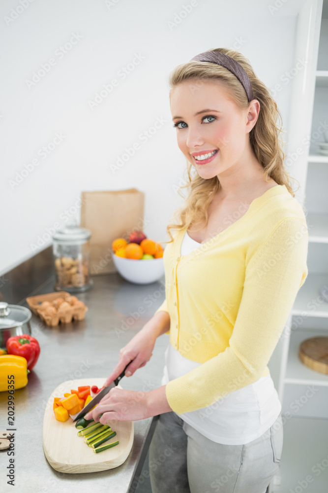 Smiling cute blonde chopping vegetables Smiling cute blonde chopping vegetables
