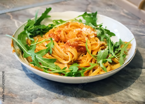 Spaghetti with tomato sauce on the wooden table