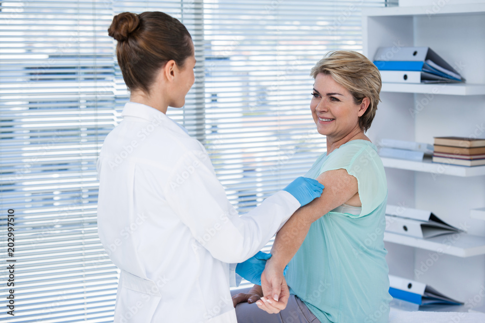 Fototapeta premium Doctor giving injection to patient