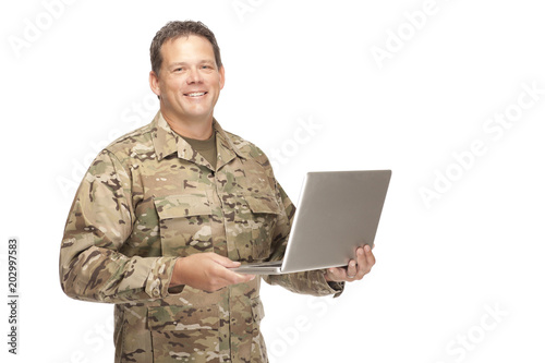 U.S. Army Soldier, Sergeant. Isolated while holding laptop.