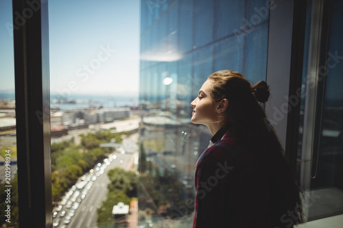 Female graphic designer looking through window