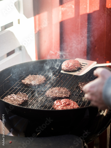 Flipping burgers on grill